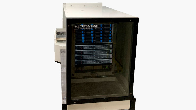 A Tetra Tech track assessment system housed in a glass-fronted cabinet with multiple components